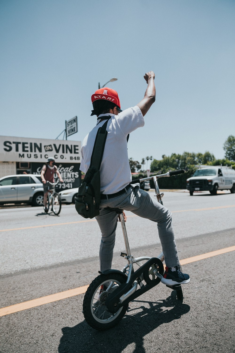 man in white long sleeve shirt and red helmet riding on black bicycle during daytime