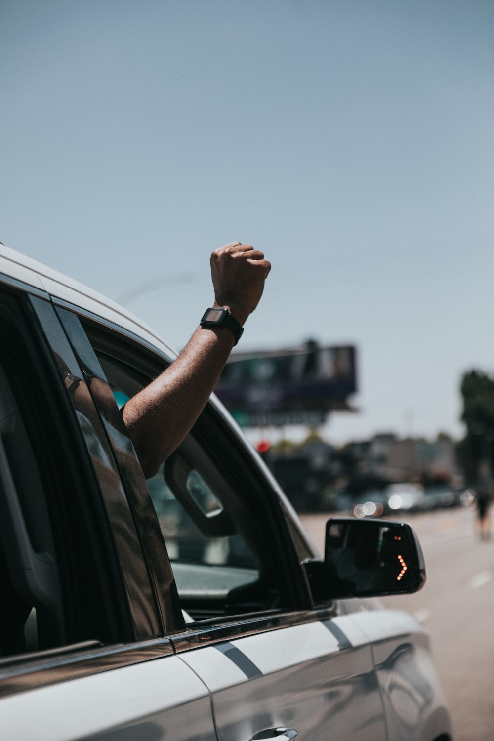 person in black watch holding car door during daytime