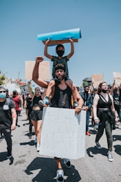 people in black shirts and black pants holding brown cardboard box