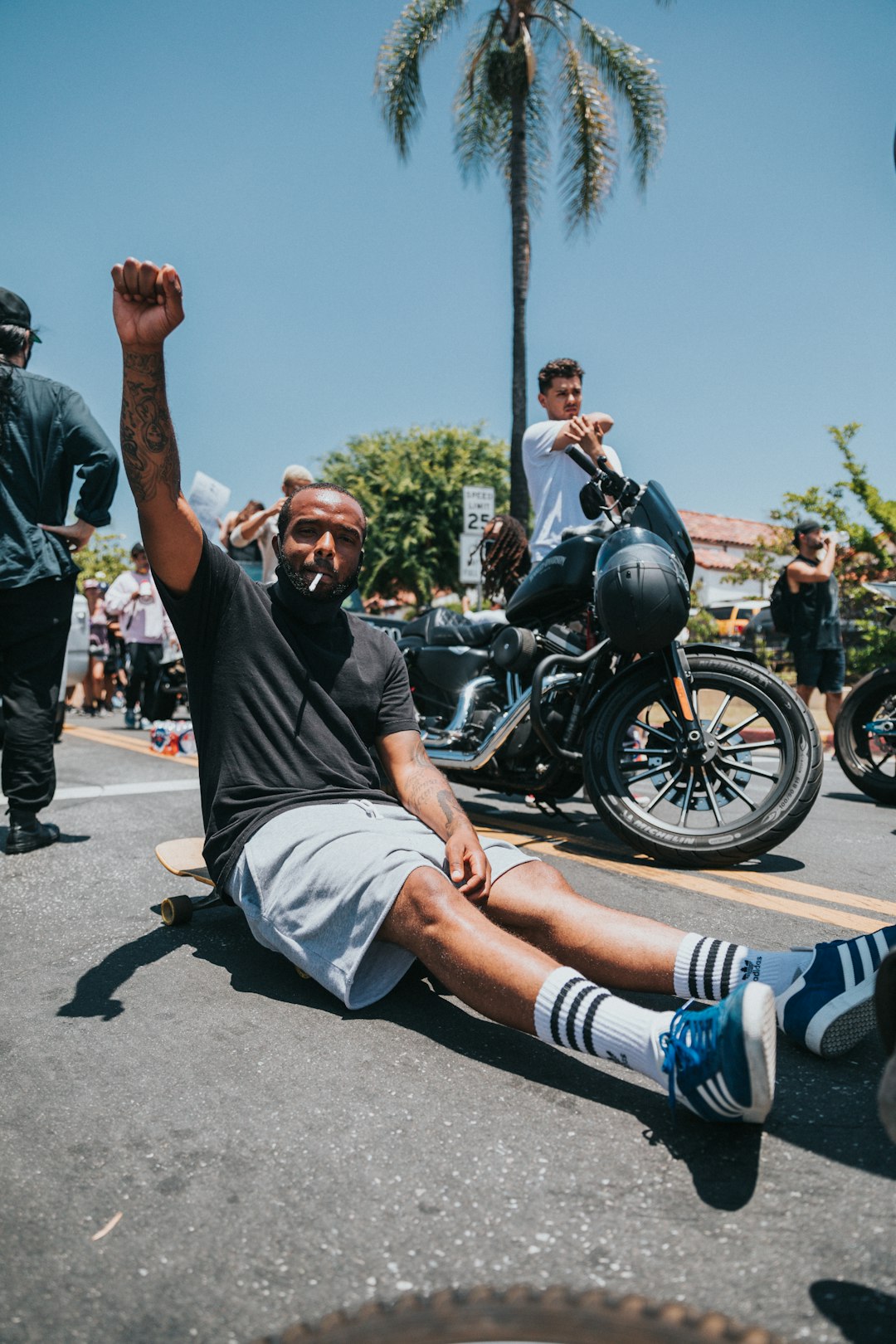 man in black t-shirt and blue shorts sitting on black motorcycle