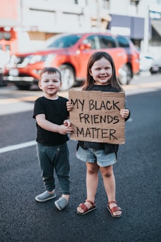 boy in black t-shirt holding brown cardboard box with girl in black t-shirt