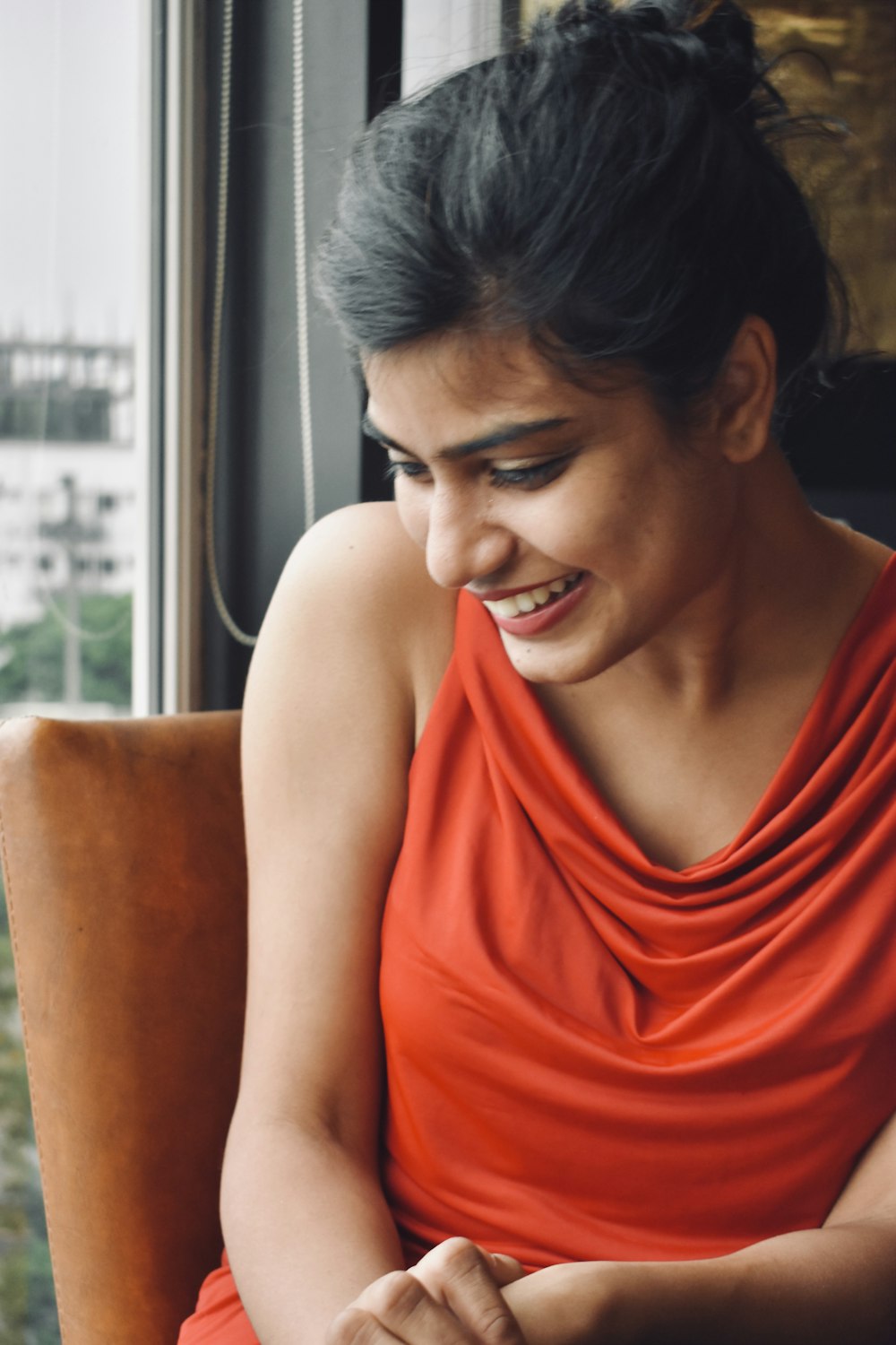 woman in red tank top sitting on brown sofa