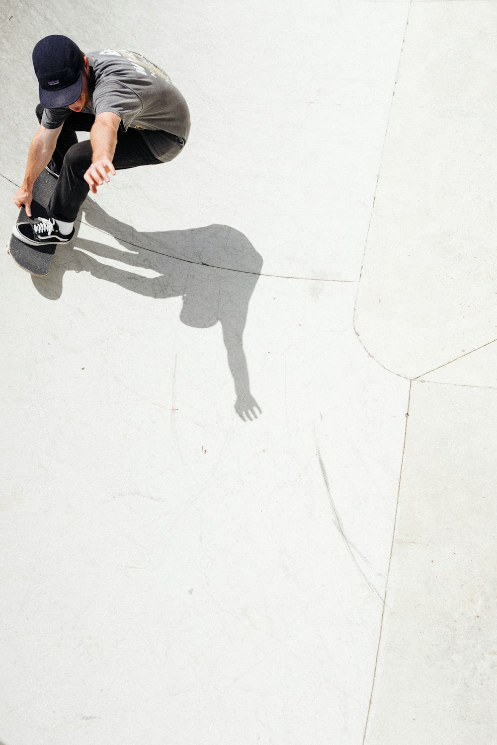 personne en short noir et chaussures noires marchant sur le sol blanc