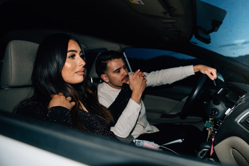 uomo e donna seduti all'interno dell'automobile