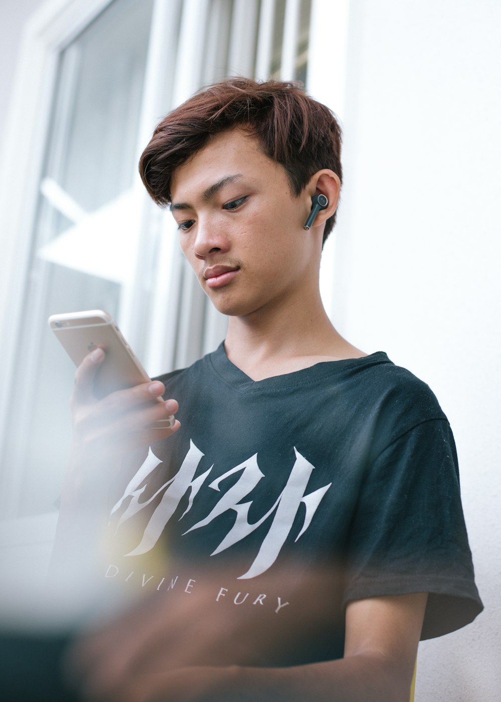 man in black crew neck shirt holding white smartphone