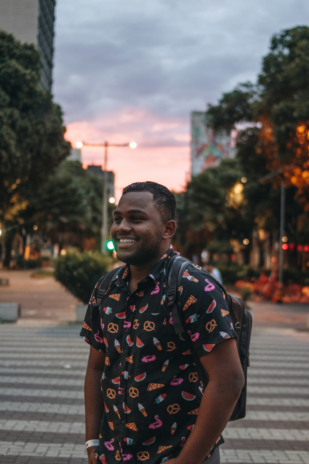 man in black white and red floral button up t-shirt standing on sidewalk during daytime