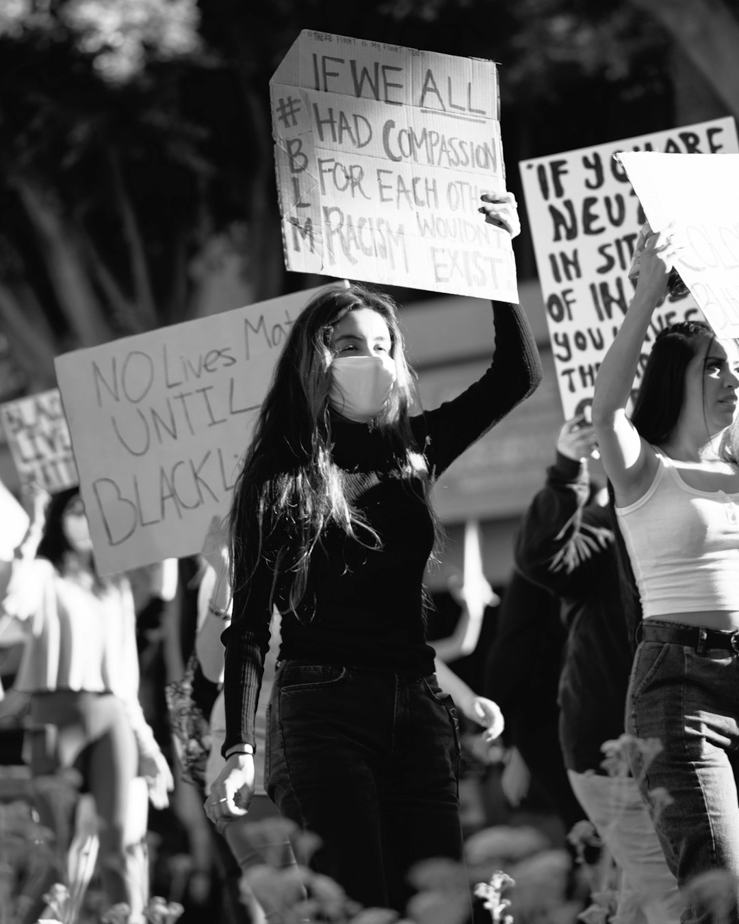 grayscale photo of woman holding white and black banner