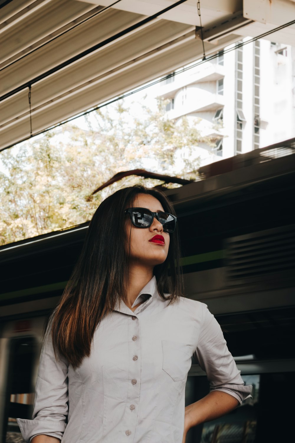 woman in white button up shirt wearing black sunglasses