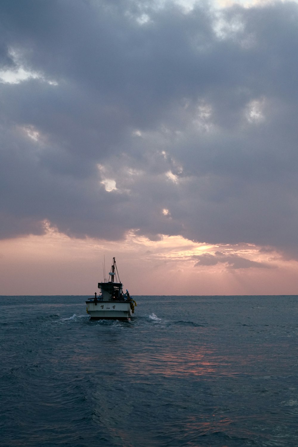 white and black boat on sea during sunset