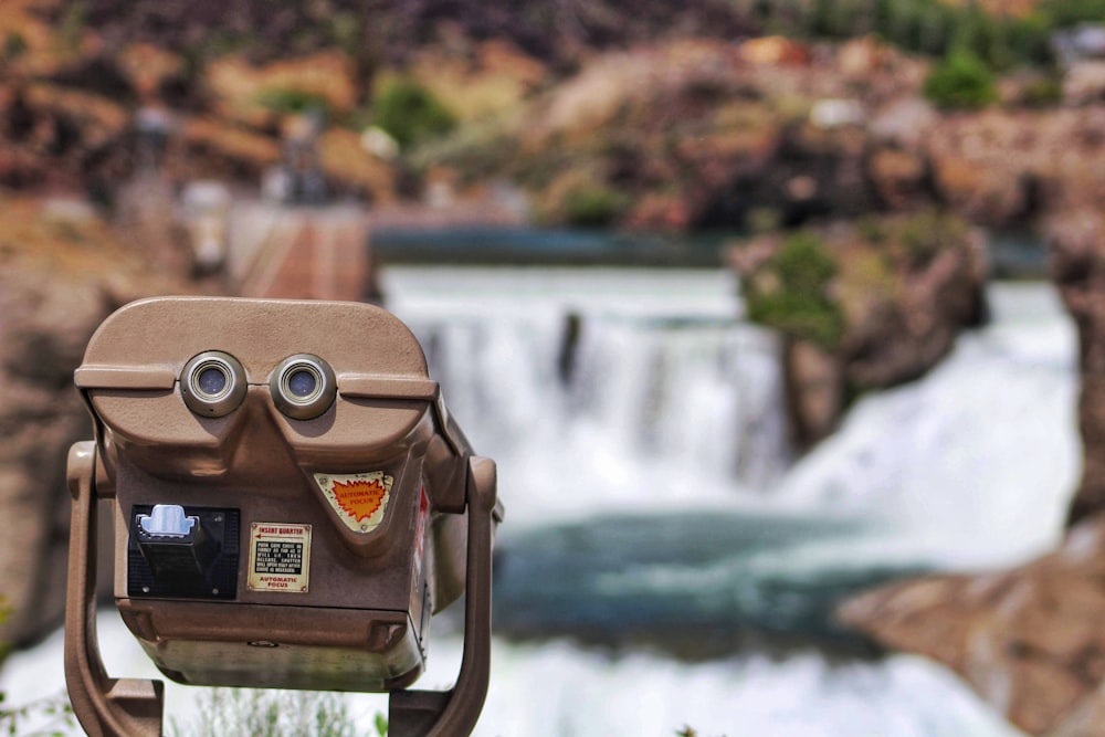 brown and black binoculars near body of water during daytime