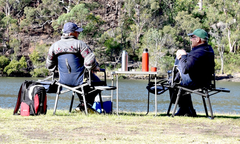 man in brown jacket sitting on blue camping chair