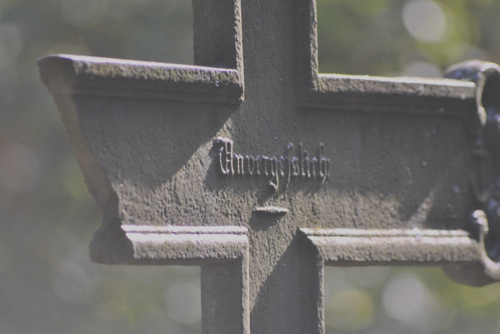 black metal cross on grey concrete wall