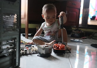 a little boy sitting on the floor playing with a toy