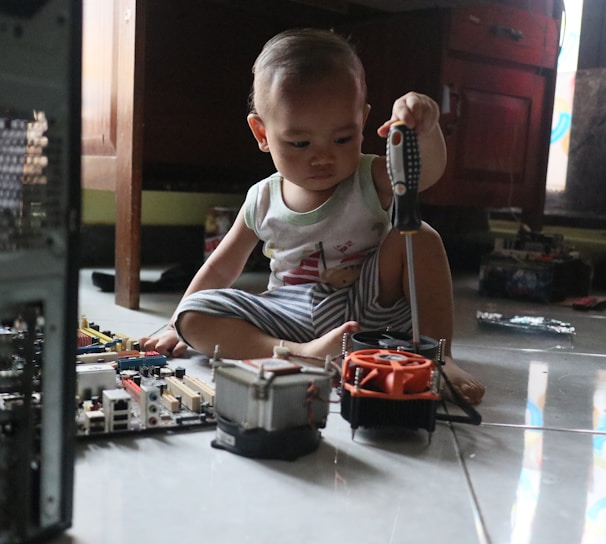 a little boy sitting on the floor playing with a toy