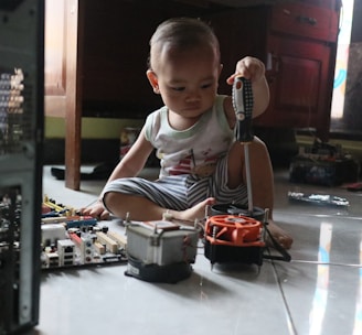 a little boy sitting on the floor playing with a toy