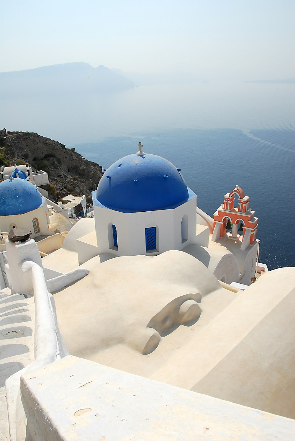 white and blue concrete building near body of water during daytime