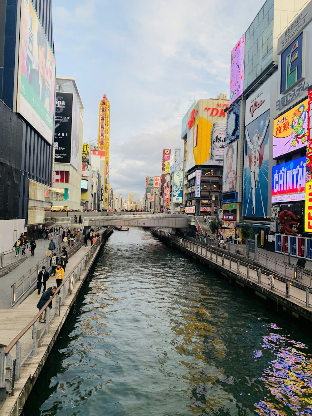 people walking on sidewalk near body of water during daytime