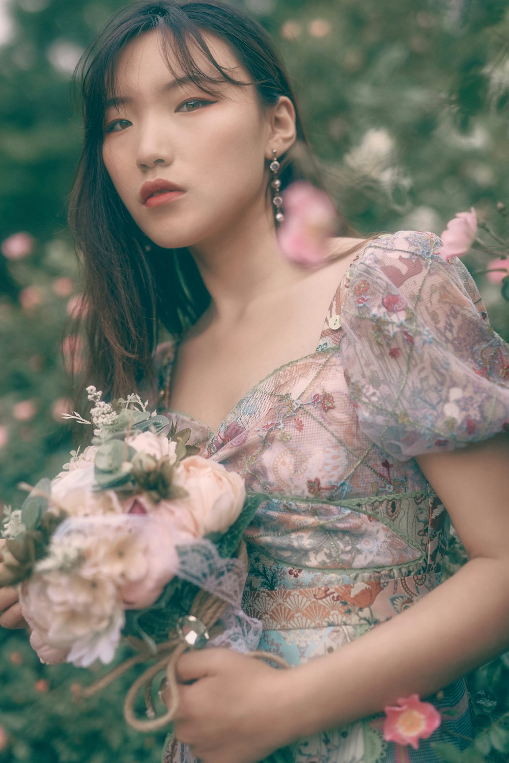 woman in white and pink floral dress holding white flowers