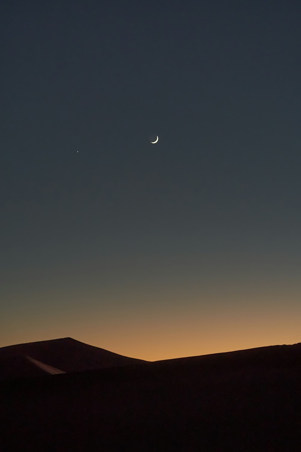 silhouette of mountain under blue sky during night time