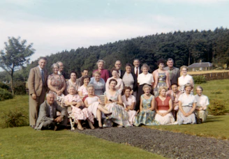 group of people sitting on green grass field during daytime