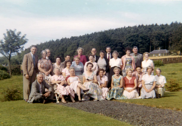 group of people sitting on green grass field during daytime