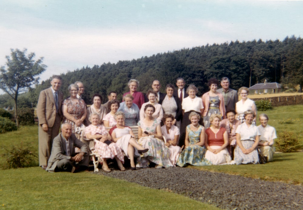 group of people sitting on green grass field during daytime