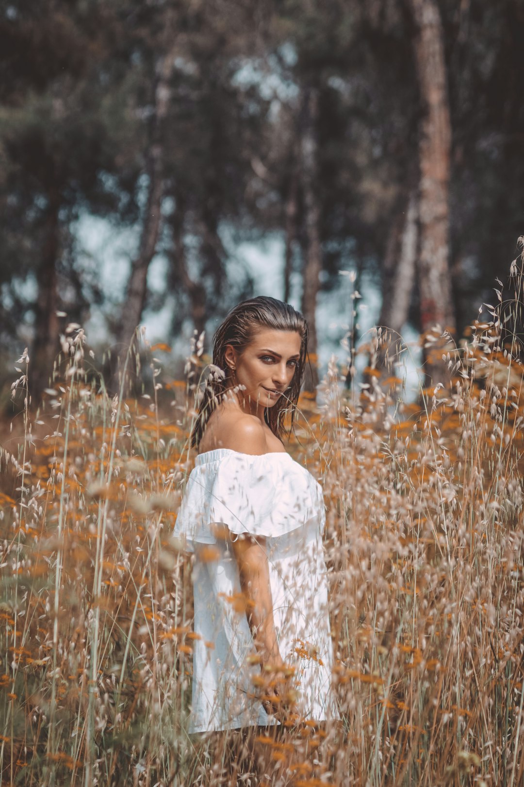 woman in white floral dress standing on brown grass field during daytime
