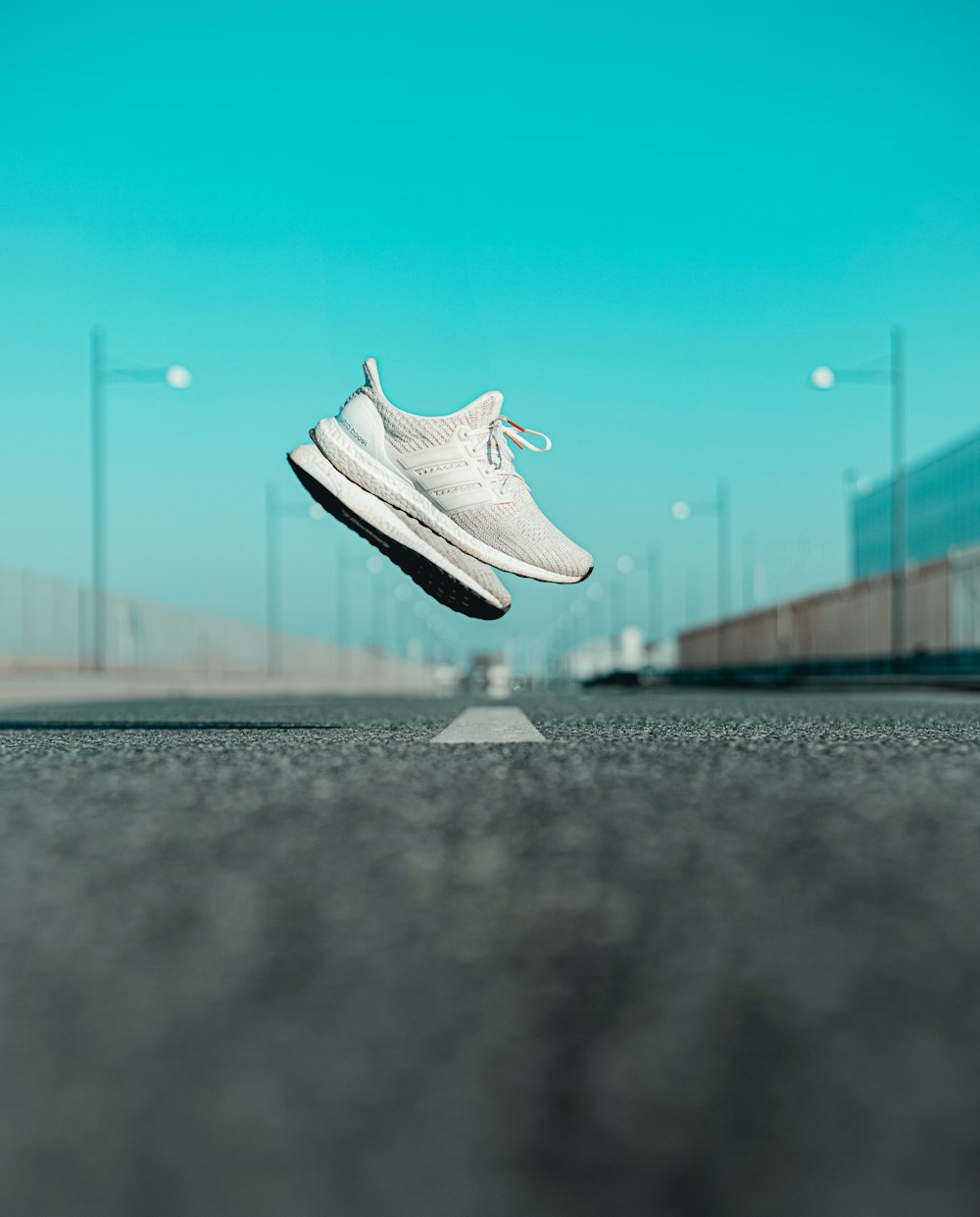 white nike athletic shoe on road during daytime