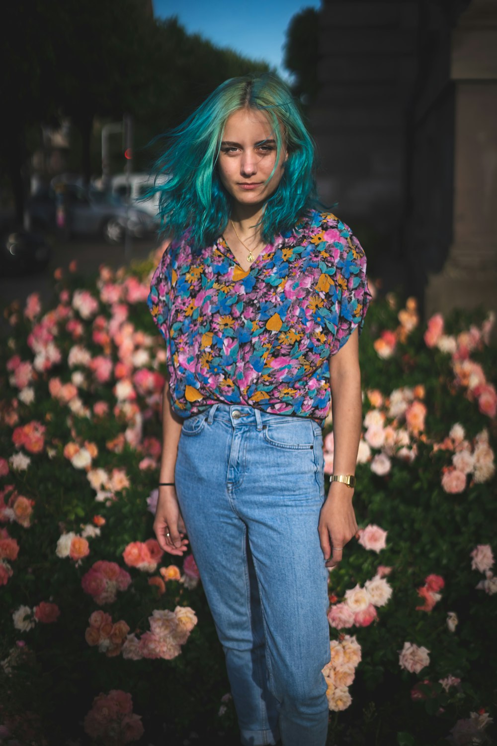 woman in blue red and white floral shirt and blue denim jeans standing on red flower