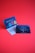 Two promotional cards against a bright red background. One card displays colorful guitar picks and has a modern design with text detailing the thickness and features. The other features a more subdued design with an image of a guitar and text about the product's new generation.