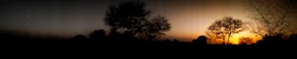A panoramic view of Chaco Canyon ruins at dusk, with the first stars beginning to twinkle above.