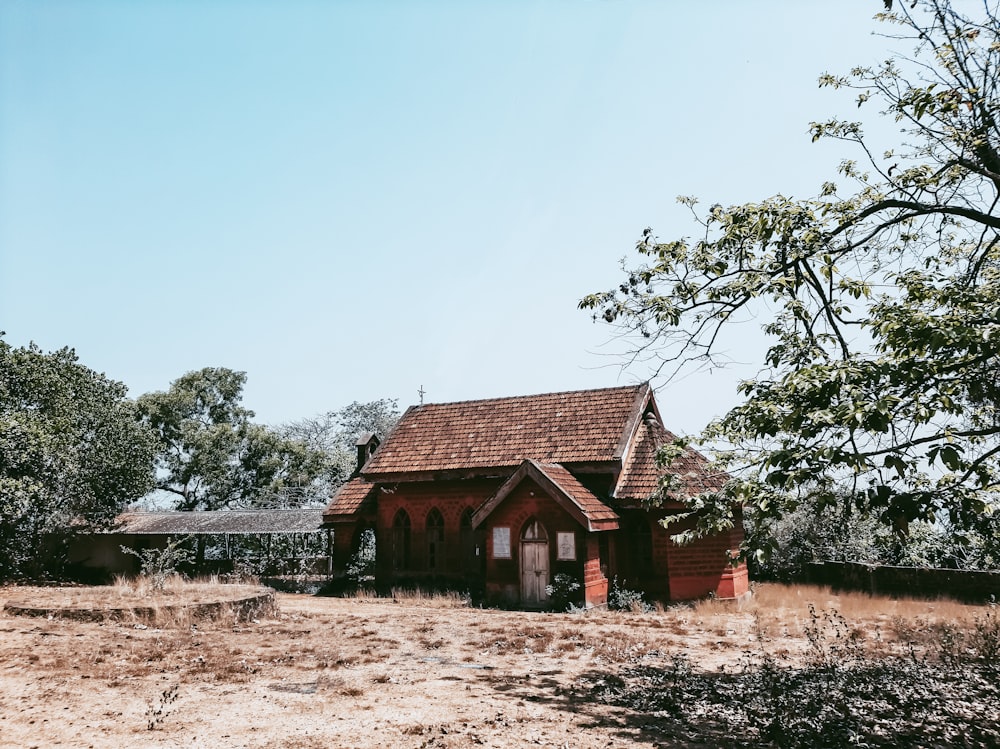 brown wooden house near green trees during daytime