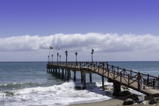 brown wooden dock on sea under blue sky during daytime