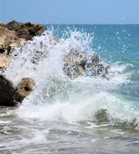 ocean waves crashing on brown rock formation during daytime in Puerto Banús Spain