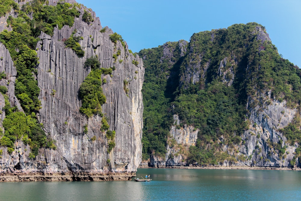 green and brown mountain beside body of water during daytime