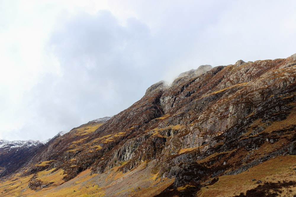 brown rocky mountain under white cloudy sky during daytime