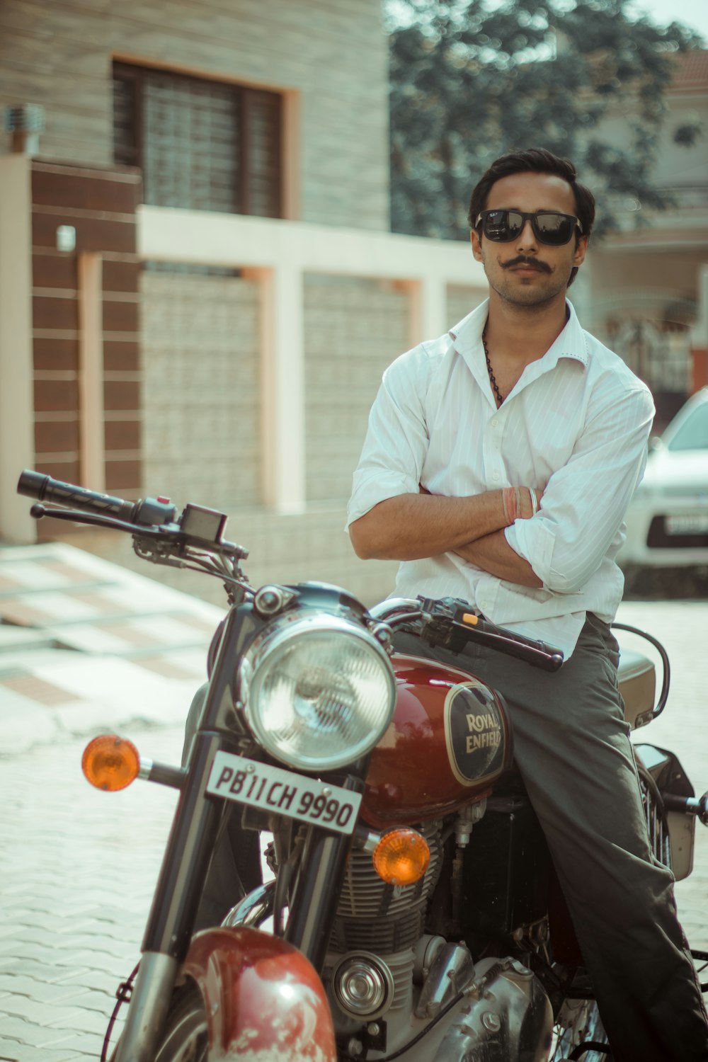 man in white button up shirt riding red and black motorcycle