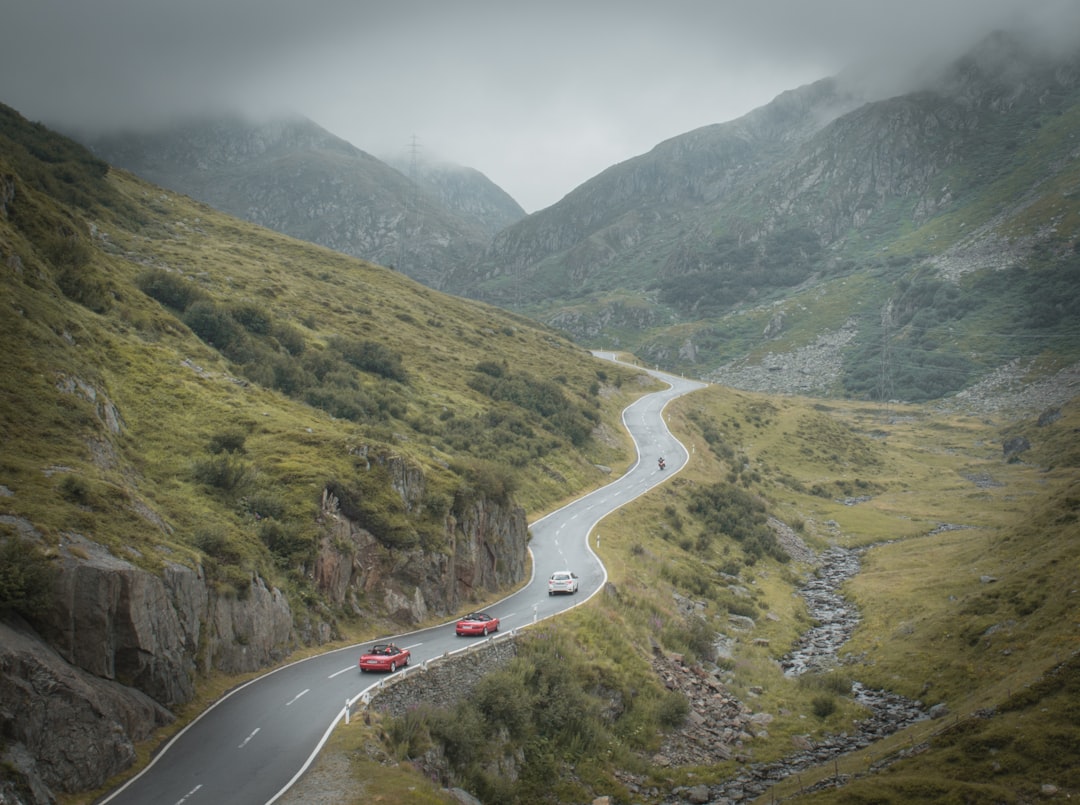 white car on road near green mountains during daytime