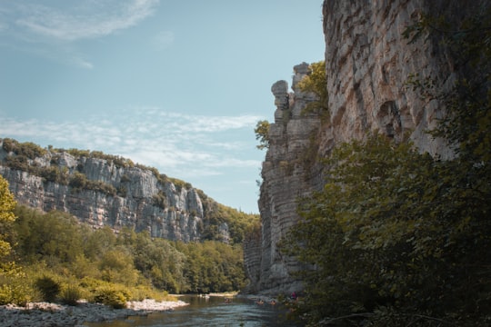 river between rocky mountains under blue sky during daytime in Ardèche France
