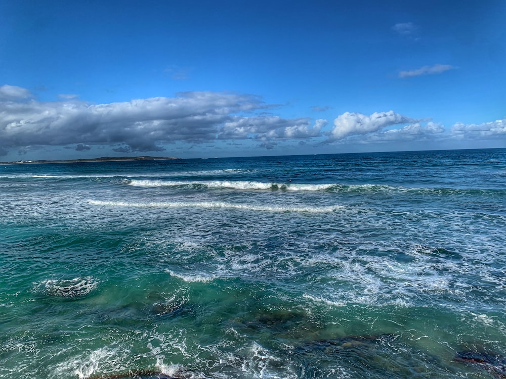 ocean waves under blue sky during daytime