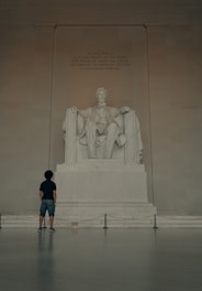 man in black t-shirt standing in front of statue