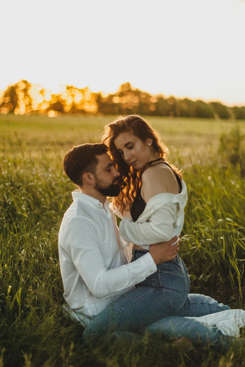 woman in white long sleeve shirt and blue denim jeans kissing woman in brown long sleeve