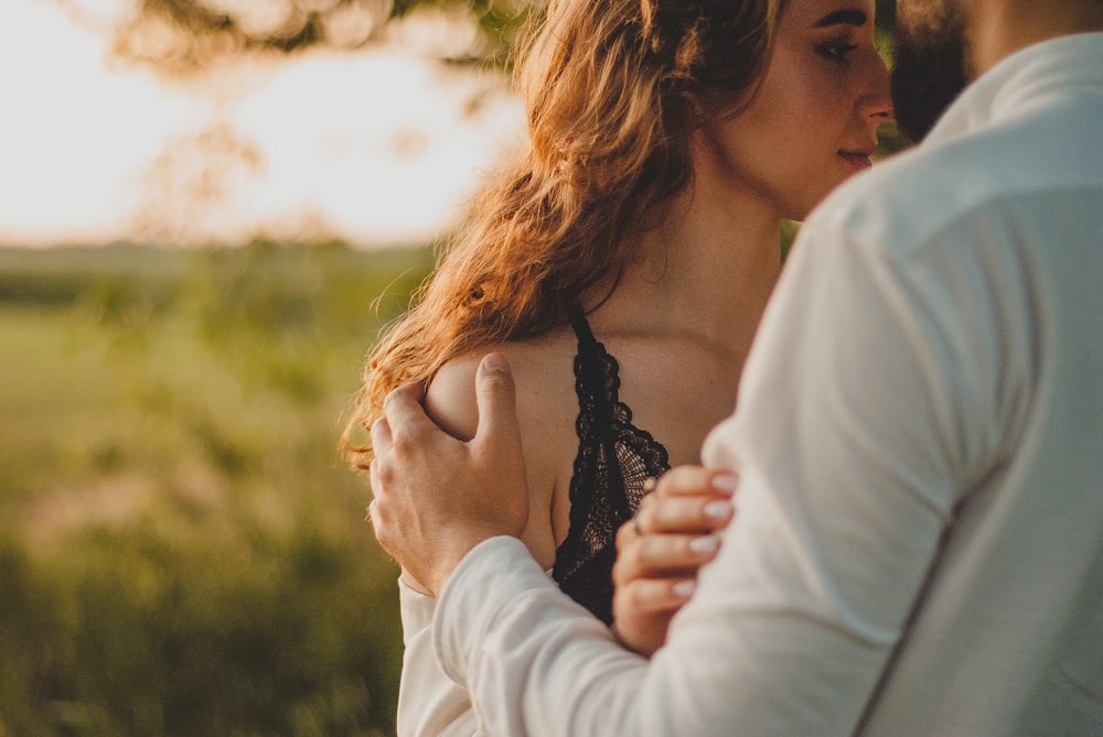 woman in black and white polka dot top kissing man in white long sleeve shirt