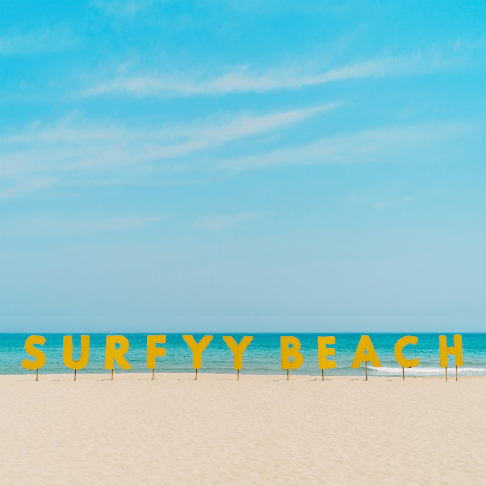 yellow and black beach umbrellas on white sand under blue sky during daytime