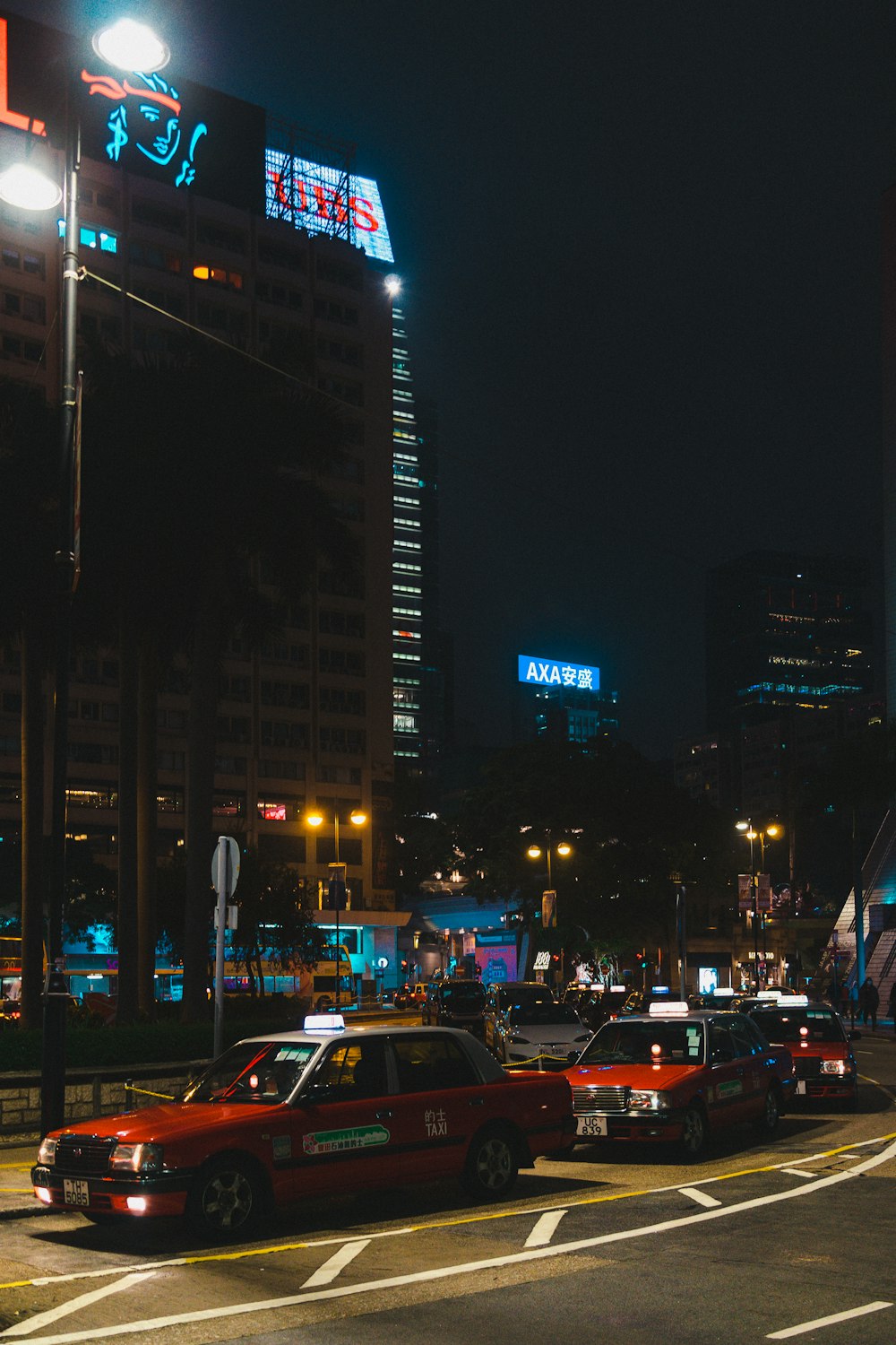 Coches en la carretera cerca de edificios de gran altura durante la noche