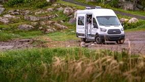 white van on green grass field during daytime