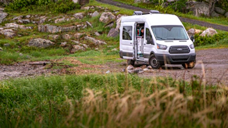 white van on green grass field during daytime