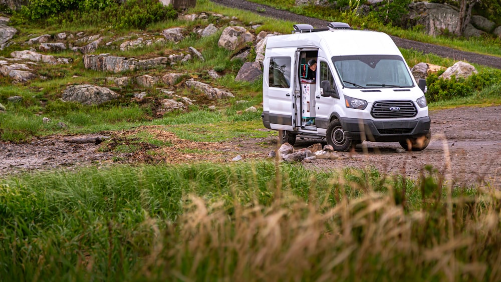 white van on green grass field during daytime