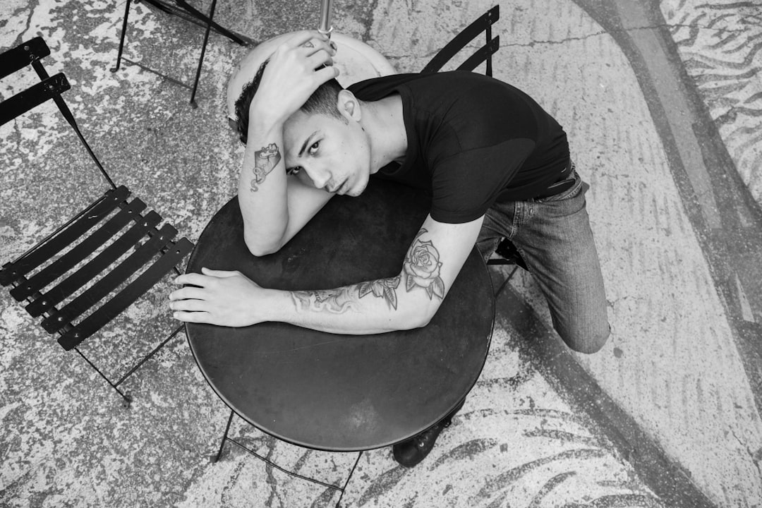 man in black t-shirt lying on black round chair