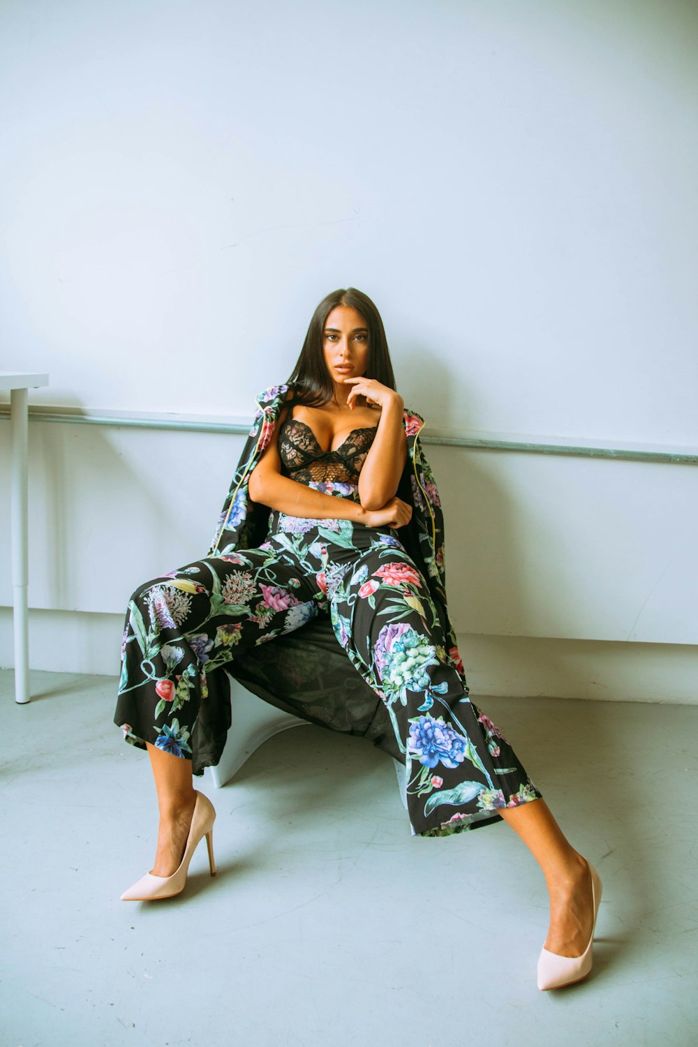 woman in black and white floral dress sitting on white floor